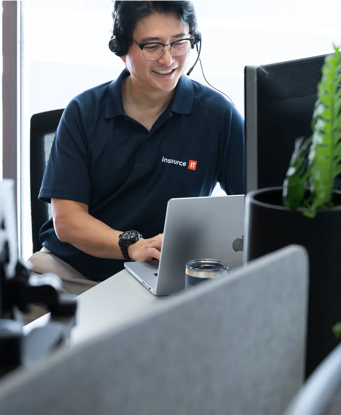 Insource IT engineer on a headset working at a laptop