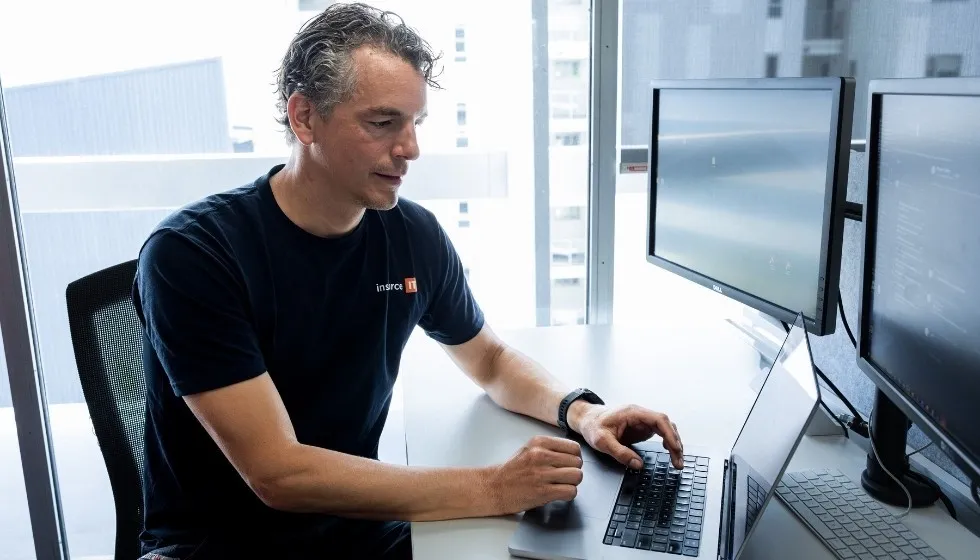 Hassan, founder of Insource IT, working at his desk